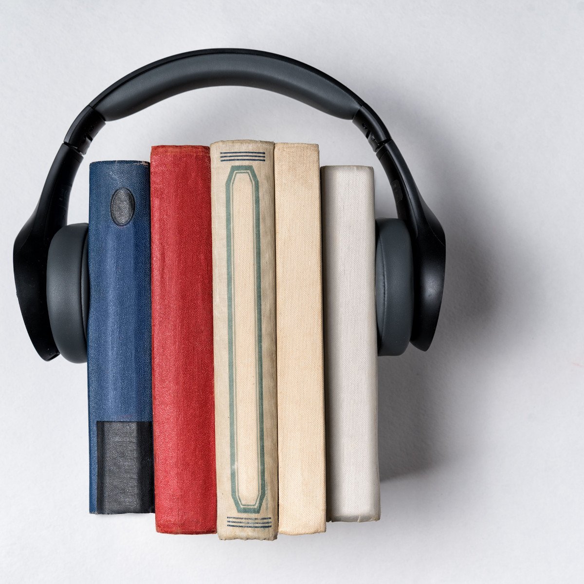 stack of books with headphones