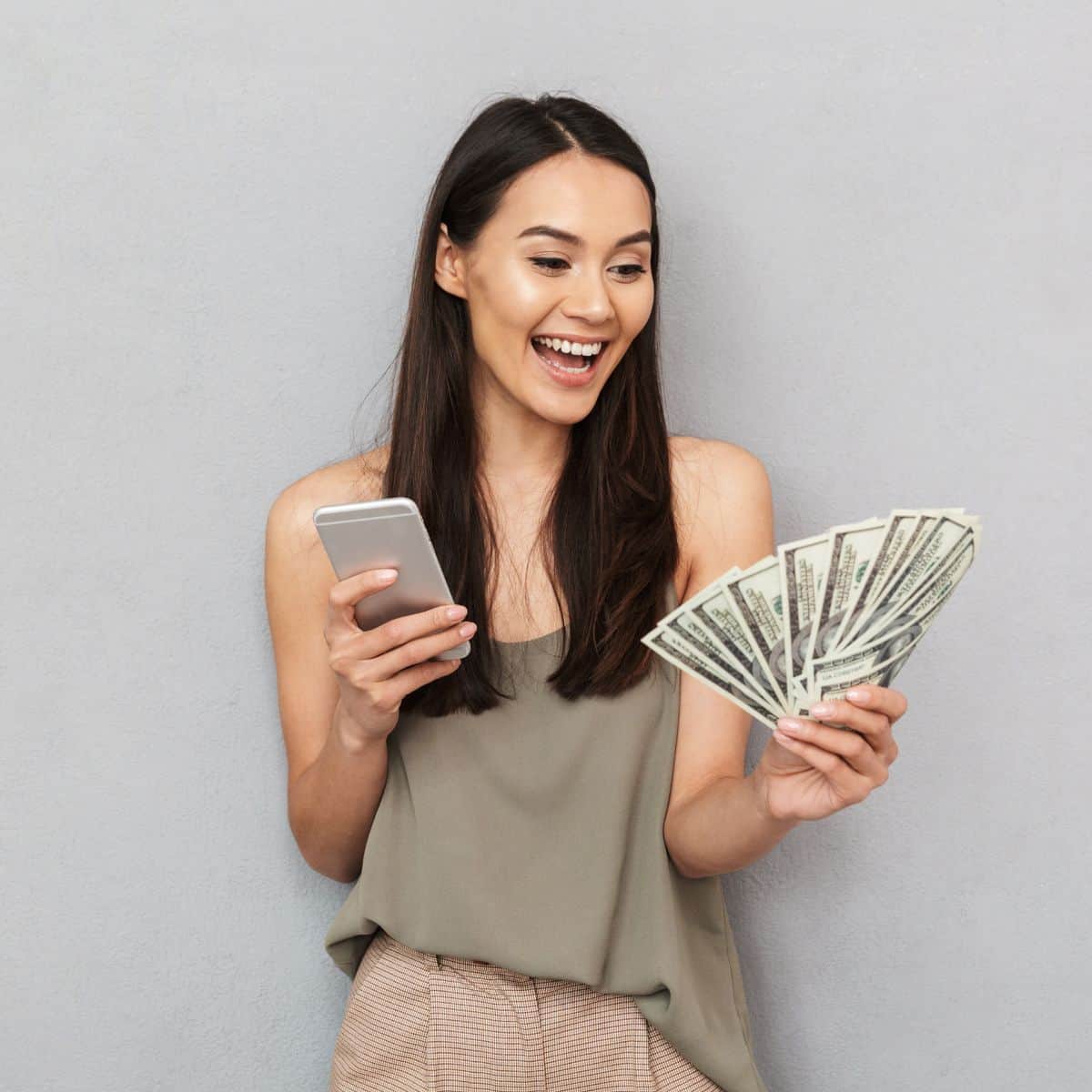 woman holding cell phone and money