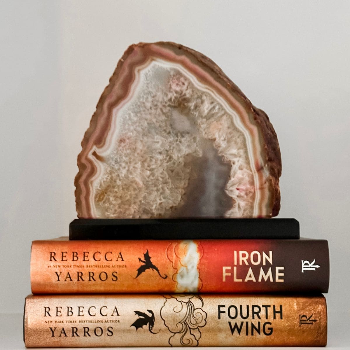 fourth wing and iron flame by rebecca yarros with an agate stone.