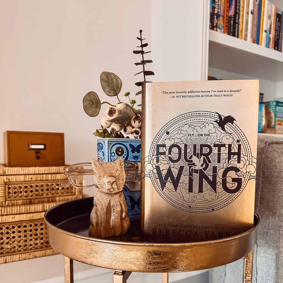 fourth wing by rebecca yarros in a reading room.