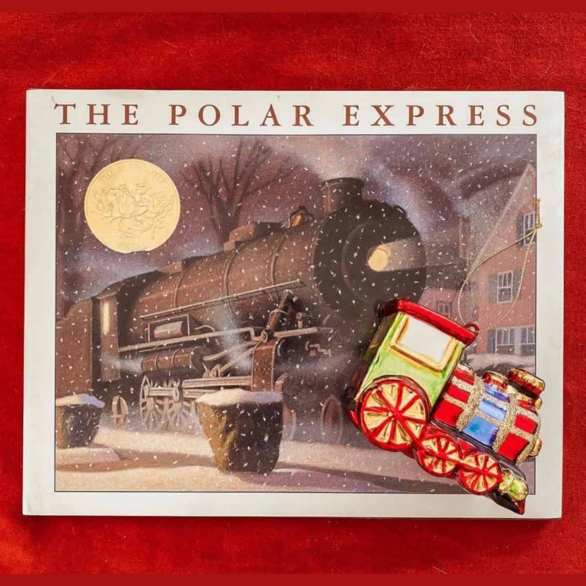 the polar express by chris van allsburg with train ornament.